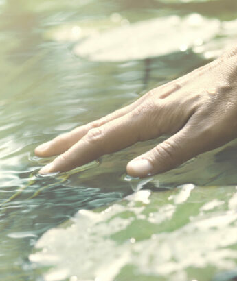 person touches the water with his hand